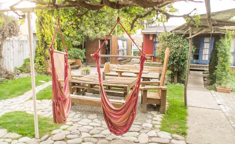 YHA Golden Bay communal outdoor dining table area with hammocks