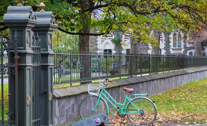 YHA Christchurch bike leaning on wall of botanical gardens