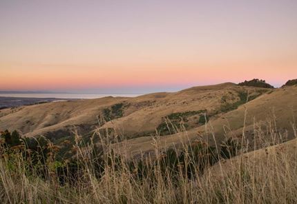 Christchurch Port Hills at dusk with a pink sky on the horizon.