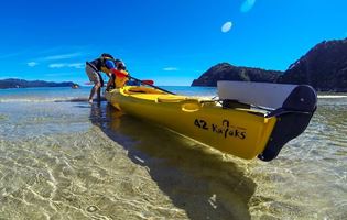 Yellow able tasman kayak on beachfront
