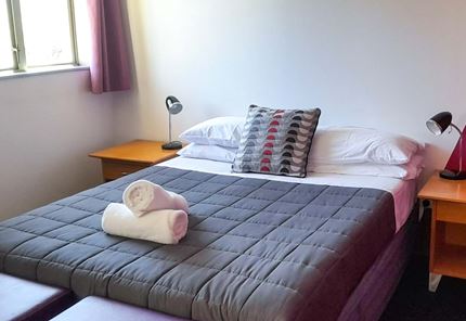 Double room at YHA Nelson set up for couples with double bed and towels.
